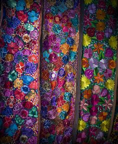 three rows of colorful fabric with flowers on them