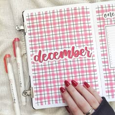 a person's hand on top of a planner with the word december written in it