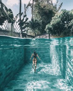 a person swimming in the water with palm trees behind them and an underwater pool that looks like it's floating