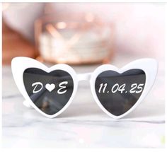 two heart shaped sunglasses with the words love and date printed on them, sitting on a table