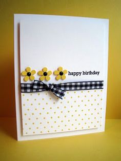 a birthday card with yellow flowers and black ribbon on the front, sitting on a table