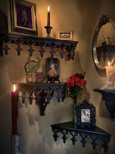 a shelf with candles and flowers on it next to a mirror, clock and other items