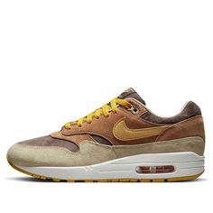 The Nike Air Max 1 Premium 'Ugly Duckling Pecan' is a stylish sneaker that is perfect for everyday wear. It features a brown leather upper with a yellow Swoosh, and a rubber sole for extra traction. The inspiration behind the design comes from the Baroque era, with the layered brown and beige leather covering the midfoot and mudguard. The yellow Swoosh and embroidered duck on the heel complete the look. This sneaker is suitable for a variety of activities, from running errands to going out with friends. (SNKR/Retro/Unisex/Low Top) Brown Boost Midsole Sneakers For Streetwear, Brown Sneakers With Boost Midsole For Streetwear, Brown Custom Sneakers With Rubber Sole For Streetwear, Brown Suede Sneakers For Streetwear, Urban Brown Sneakers For Streetwear, Brown Urban Sneakers For Streetwear, Nike Brown Suede Sneakers, Brown Sports Sneakers With Rubber Sole, Custom Brown Suede High-top Sneakers