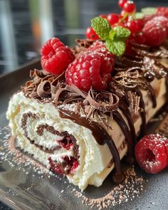 a piece of cake with chocolate and raspberries on top