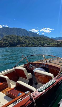 there is a boat that is docked at the dock in the water with mountains in the background