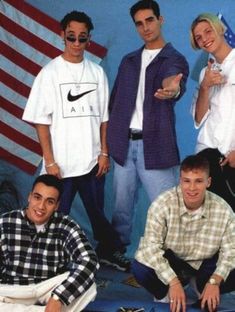 a group of young men standing next to each other in front of an american flag