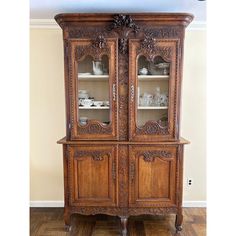 an old wooden china cabinet with glass doors