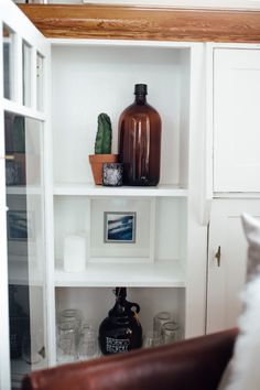 a white shelf filled with vases and other items