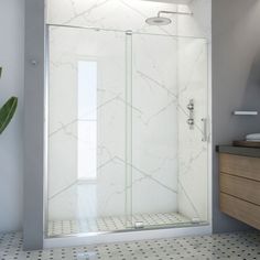 a bathroom with a glass shower door and tiled floor