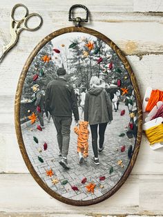 an image of a man and woman walking with a small tiger on the sidewalk in front of them