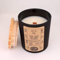 a candle that is sitting next to some sort of wooden container on a white surface