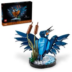 a blue bird figurine sitting on top of a plant