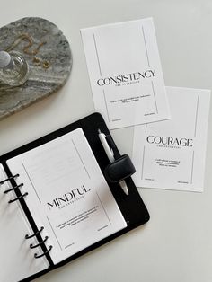 three black and white notebooks sitting on top of a table