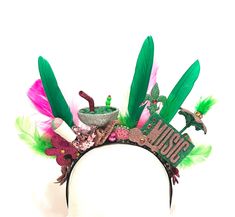 You'll be the most festive at every New Orleans festival wearing this lightweight headband!   The headband is covered with glittery music instruments, fleur-de-lis, crowns, snoballs, a cocktail, and a second line umbrella, all accented with pink and green feathers.  The back is finished with flowers and ribbons so you'll look great coming and going. These are great for any New Orleans event, but they're also great for any festival anywhere. (I specially treat the glitter so there's little to no shedding.) Happy Festing! New Orleans Festivals, Festival Headband, Festival Wear, Hair Accessories Headbands, New Orleans, Pink And Green, Looks Great, Hair Accessories, Festival