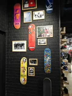 several skateboards are hanging on the wall next to each other in a room with black brick walls