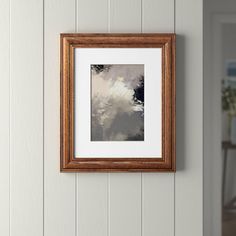 an empty wooden frame hanging on the wall above a white painted wood paneled door