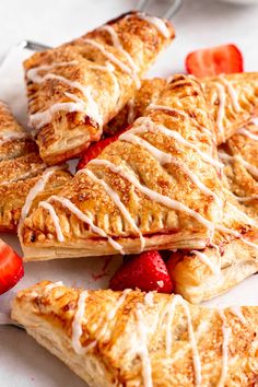 strawberry turnovers with icing and strawberries on a plate