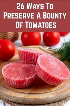 two pieces of raw meat sitting on top of a wooden cutting board with tomatoes in the background