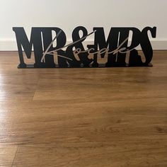 a couple of metal letters sitting on top of a hard wood floor next to a wall