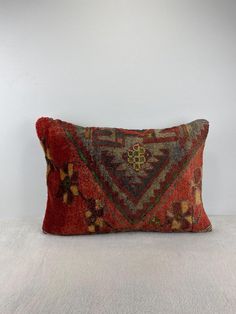 a red pillow sitting on top of a white floor