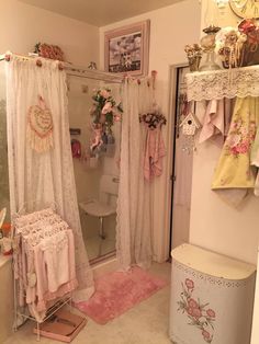 a white bathroom with pink rugs and curtains