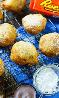 several pastries on a cooling rack with powdered sugar next to them and a bag of peanut butter