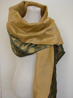 Our Beyond Luxury Wrap is truly couture. Two sided shawl made of 100% silk with a twist. A Go Kismet Original which I found in Italy and then reproduced as an affordable option. One side of the shawl is made of raw silk. Raw silk has a depth to it which most fabrics do not. Formidable and textured. Light is captured and plays off the natural threads. One size fits most.The reverse side of the shawl is made of silk damask. Each panel has been woven with gold or silver threads creating an engineer Traditional Silk Scarves For Formal Occasions, Elegant Silk Scarves In Traditional Drape, Elegant Silk Scarves With Traditional Drape, Festive Green Silk Shawl, Traditional Gold Silk Scarf, Formal Festive Silk Shawl, Elegant Tussar Silk Pashmina Shawl, Elegant Silk Mark Certified Silk Dupatta, Traditional Gold Silk Scarves