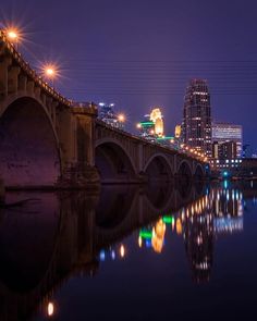 a bridge that has lights on over it and some buildings in the background at night