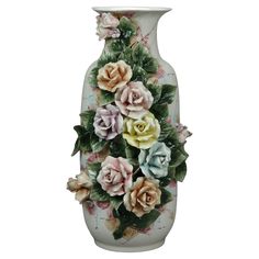 a white vase filled with lots of different colored flowers