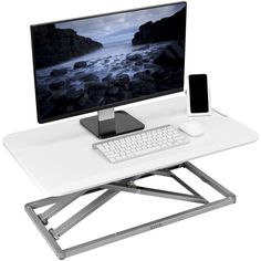 a computer desk with a keyboard, mouse and phone sitting on it's stand