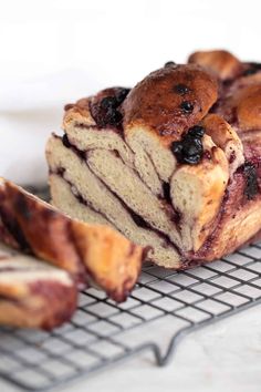 a loaf of blueberry bread sitting on top of a cooling rack