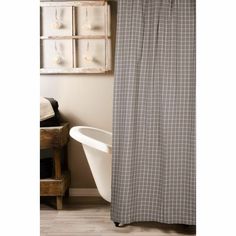 a white bath tub sitting next to a shower curtain in front of a wooden shelf