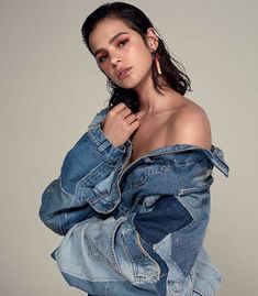 a woman in a jean jacket posing for the camera with her hands on her hips