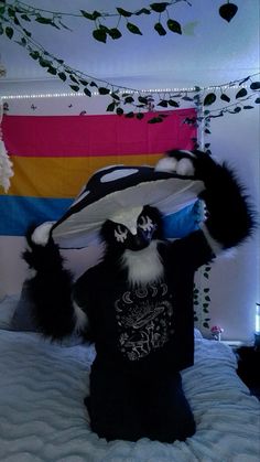 a bed with a stuffed animal on top of it's head in front of a colorful wall