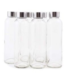 four glass beverage bottles with silver lids