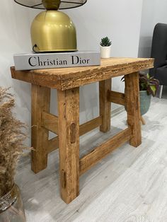 a wooden table with a book on it and a lamp in the corner behind it