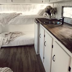 a kitchen area with a sink, counter and bed