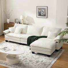 a white couch sitting on top of a rug in a living room