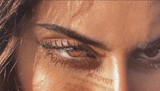 a woman's eye with long lashes and brown eyeshadow, close up