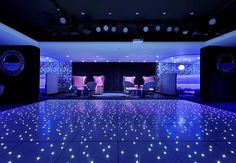 a dance floor is lit up with blue lights