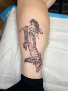 a woman's leg with a tattoo on it that has an image of a person holding