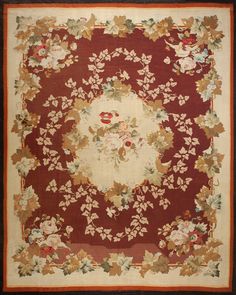 a red and white rug with flowers on the center, surrounded by other floral designs