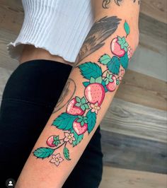 a woman's arm with an owl and strawberrys tattoo on her left arm