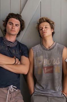 three young men standing next to each other with their arms crossed in front of them