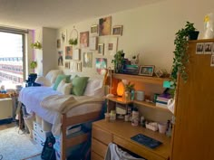 a bed room with a neatly made bed and lots of pictures hanging on the wall