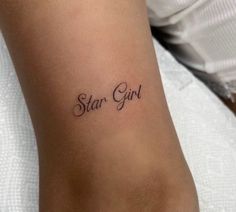 a woman's arm with the word star girl tattooed on her left side, in cursive font