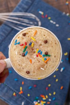 a person holding a cup with sprinkles on it