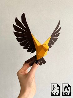 a hand holding an origami bird in front of a white background with the words dxf above it