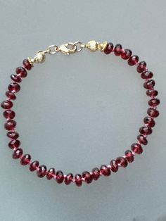 Beautiful rich red garnet gemstones, silk knotted bracelet, 14k gold filled clasp and components. 7 1/2 inches long. Gemstones are approx 5-6mm each. Faceted garnet, beautiful aaa luxe quality. Handmade Elegant Red Crystal Bracelet, Classic Red Gemstone Bracelet, Luxury Red Gemstone Bracelet, Elegant Red Hand-strung Beaded Bracelets, Luxury Garnet Gemstone Bracelets, Rough Gemstone Jewelry, Garnet Bead Bracelet, Knotted Bracelet, Pyrite Bracelet