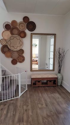 a hallway with wooden floors and baskets on the wall next to a white staircase railing